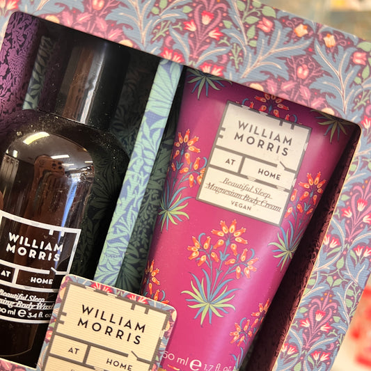 William Morris At Home gift set featuring a 'Beautiful Sleep Magnesium Body Cream' in a pink floral tube, a dark amber body wash bottle, and a decorative patterned box.