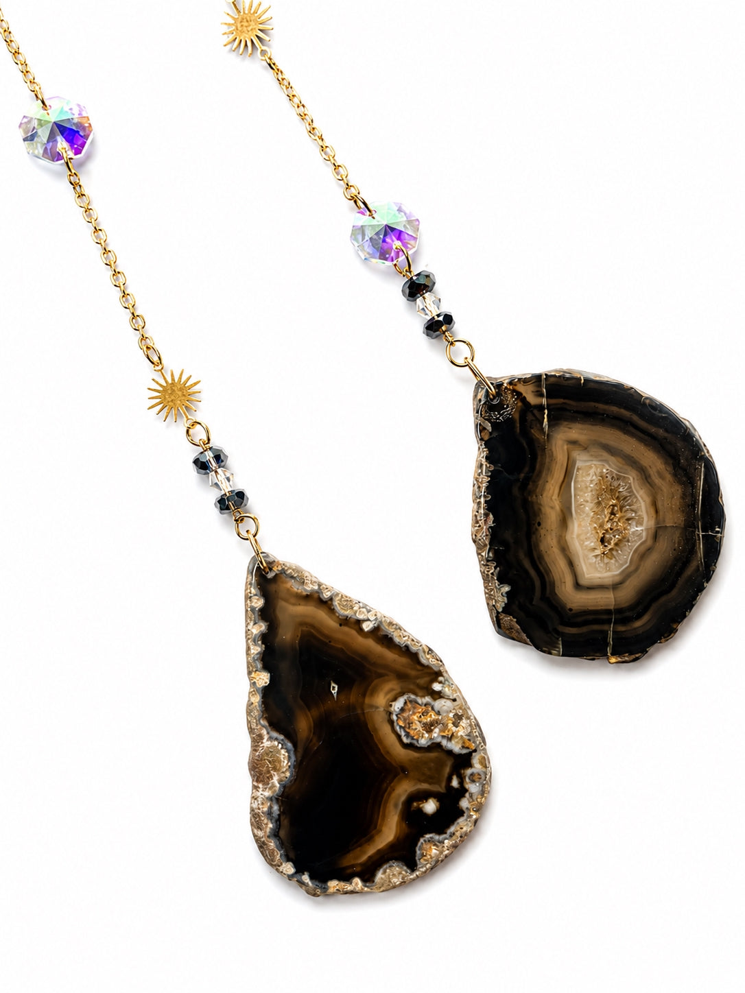 Close-up of polished black natural agate slice pendants and delicate gemstone bead chains from a crescent moon crystal dream catcher.