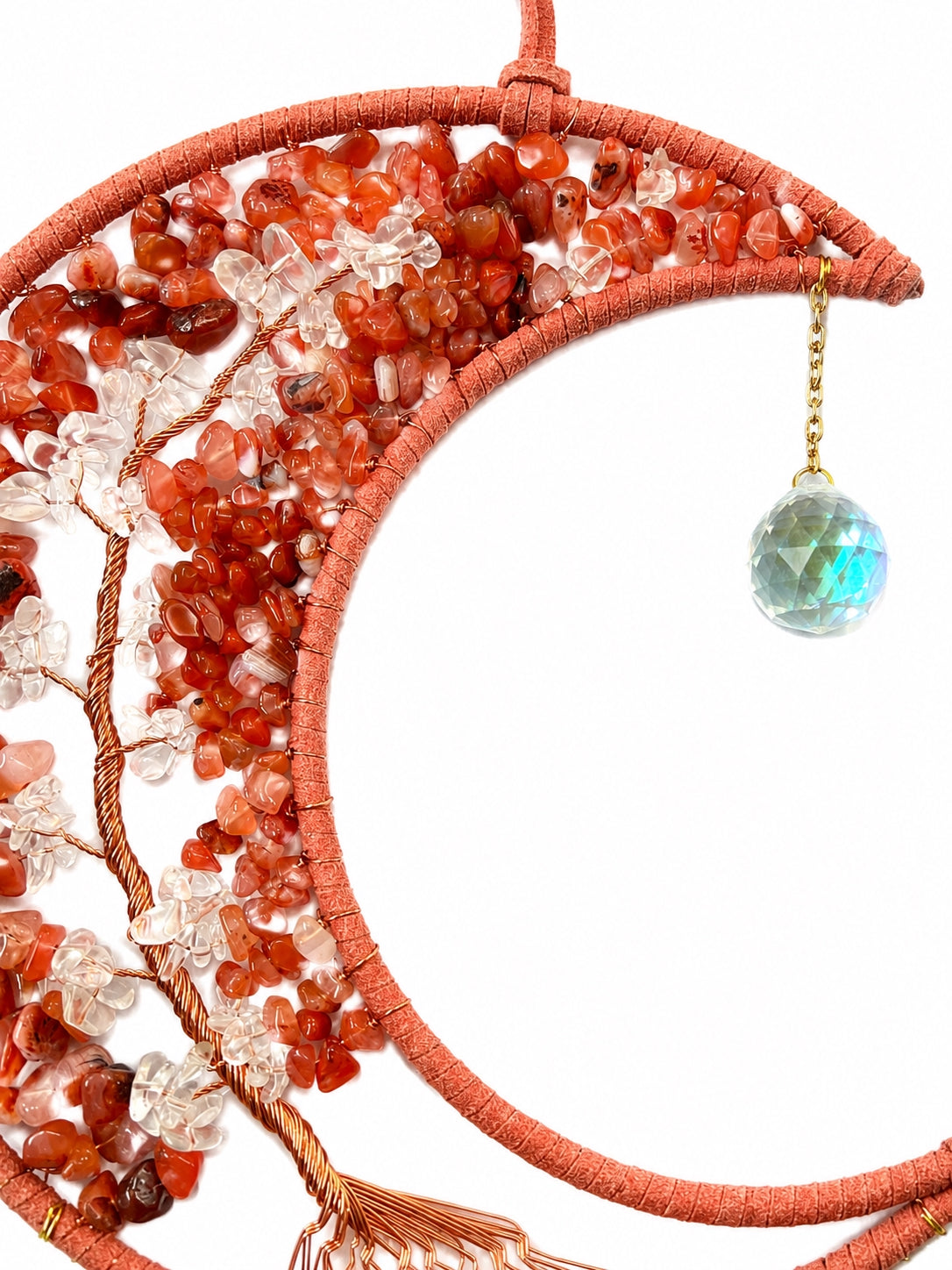 Close-up of an orange crescent moon dream catcher handcrafted with natural crystal chips, copper-toned wire and a turquoise-coloured pendant.