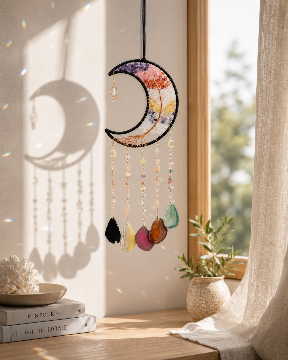 Rainbow crescent moon crystal dream catcher hanging beside a sunlit window as bright and playful boho home decor.