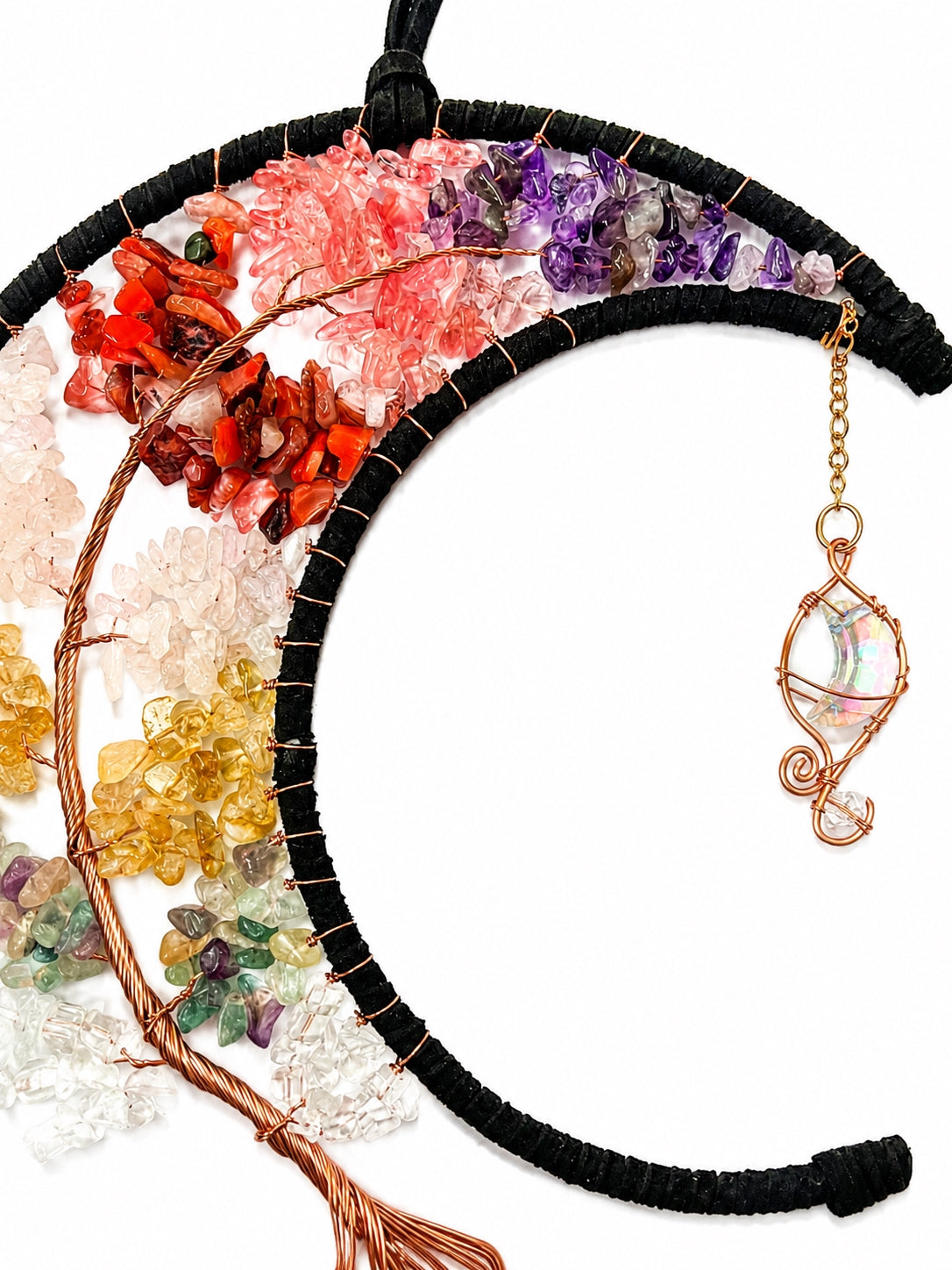 Close-up of a rainbow crescent moon dream catcher handcrafted with multicoloured natural crystal chips, dark edging and delicate wire details.