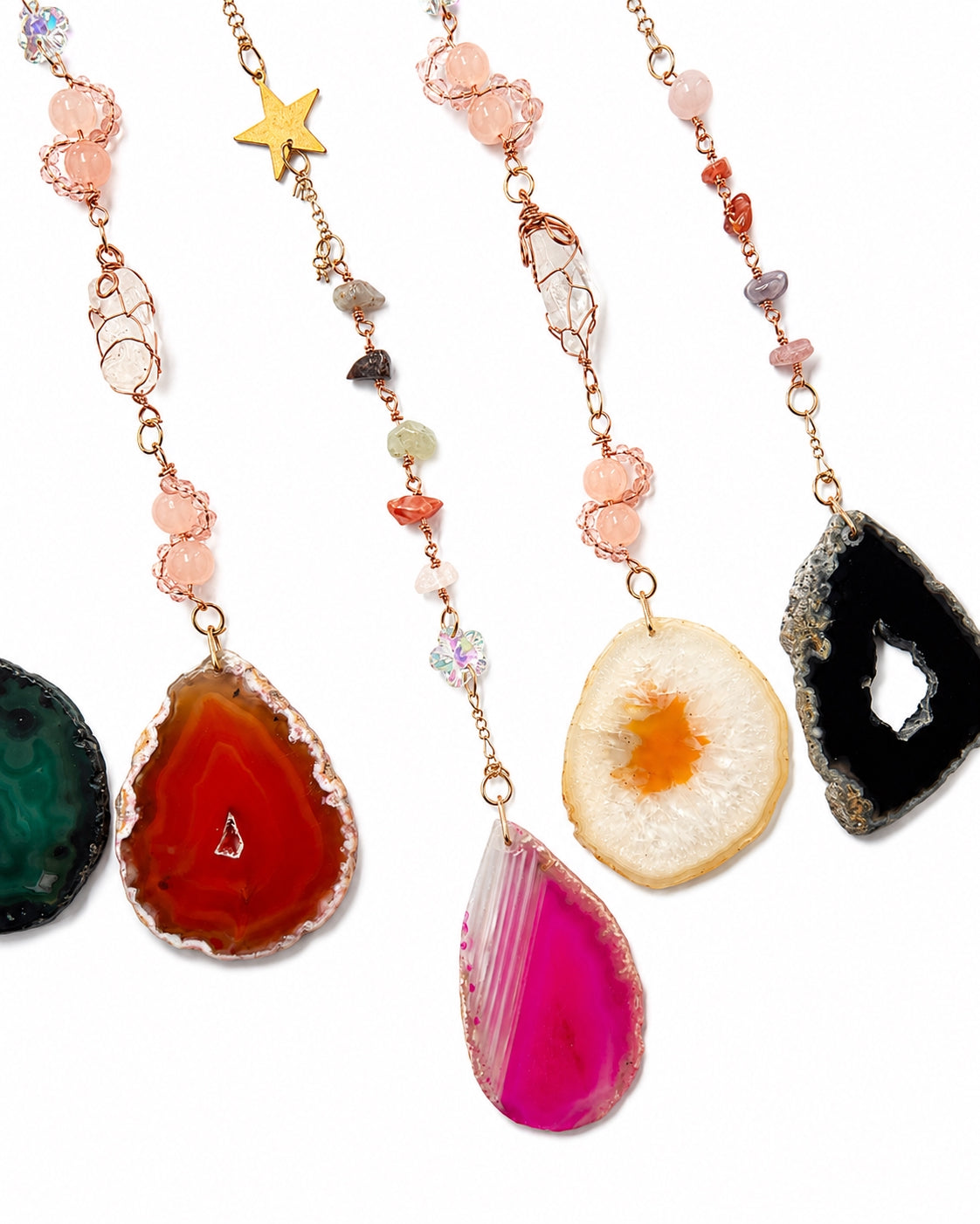 Close-up of colourful natural agate slice pendants and gemstone bead chains hanging from a rainbow crescent moon crystal dream catcher.