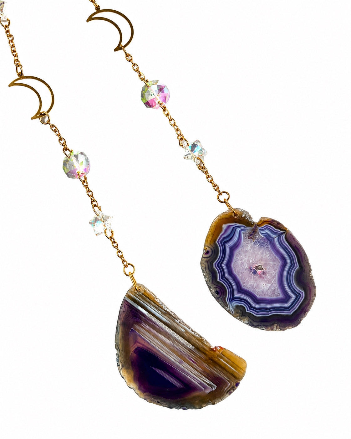 Close-up of polished purple natural agate slice pendants and delicate gold-toned chains from a crescent moon crystal dream catcher.