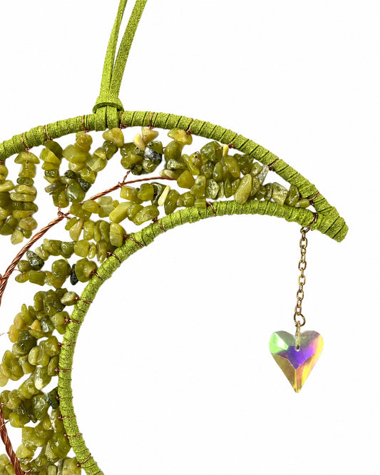 Close-up of a green crescent moon dream catcher handcrafted with natural crystal chips, gold-toned wire and a small hanging gemstone.