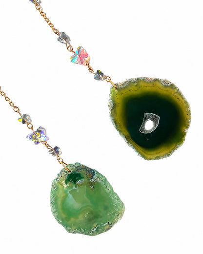 Close-up of vibrant green natural agate slice pendants and gemstone bead details from a crescent moon crystal dream catcher.