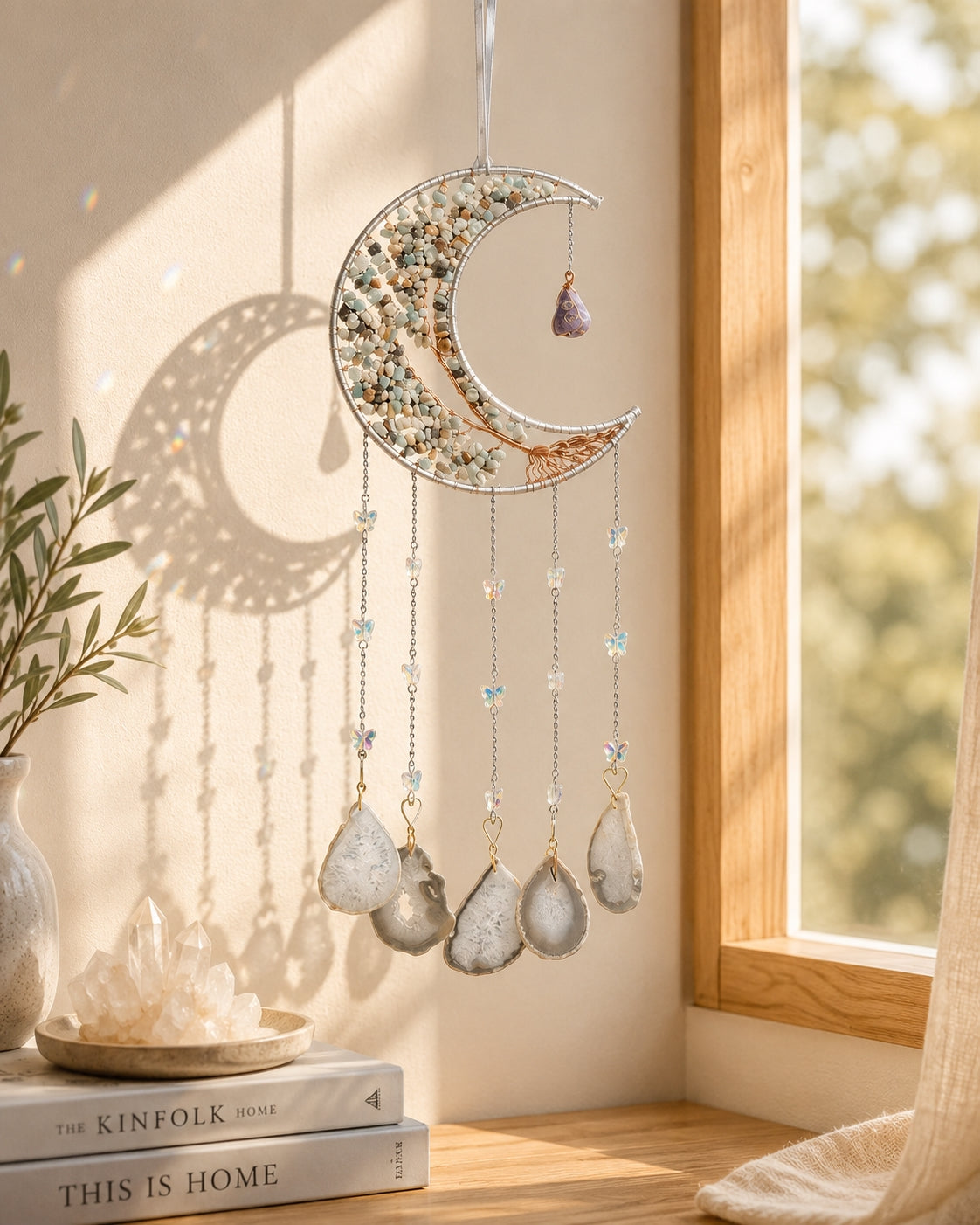 Green crescent moon crystal dream catcher hanging beside a sunlit window as an earthy piece of boho home decor.