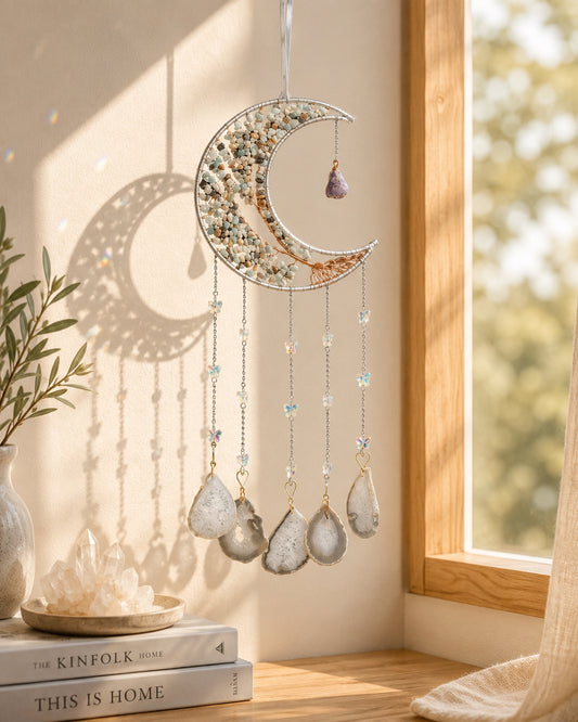 Green crescent moon crystal dream catcher hanging beside a sunlit window as an earthy piece of boho home decor.