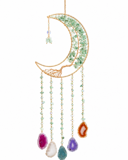 A gold crescent moon dream catcher featuring green crystal accents and dangling teardrop gemstone charms in pink, white, teal, purple, and orange, set against a plain white background.