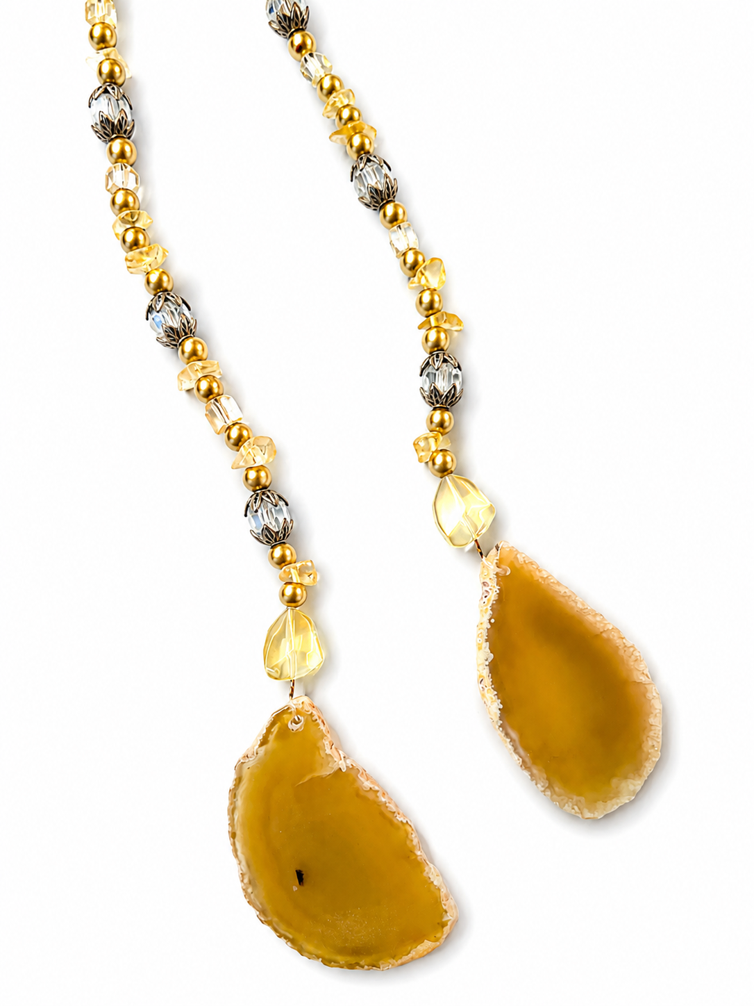 A beaded hanging pendant with gold beads, clear faceted crystal beads, and two large teardrop-shaped natural agate pendants in a warm golden-brown color, shown on a plain white background.