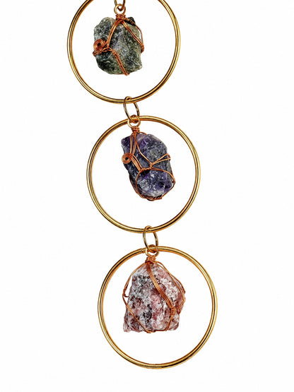 Close-up of natural crystal tree of life details in earthy colours, handcrafted with copper wire and gold-toned frames.