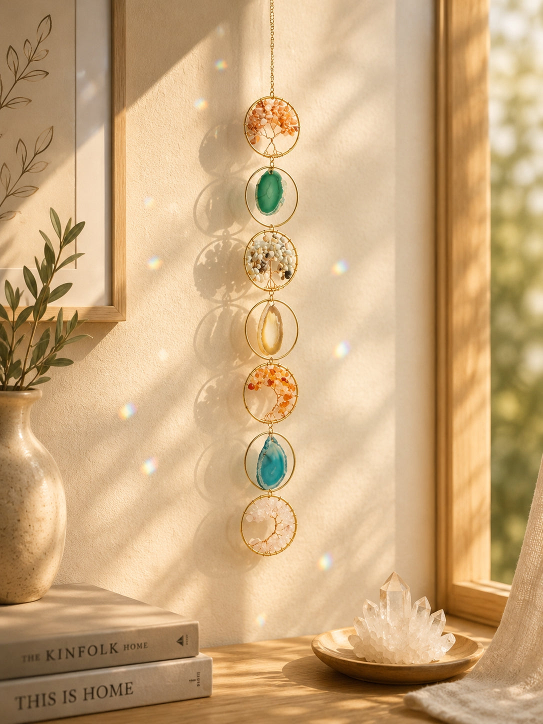 Colourful natural crystal suncatcher hanging beside a sunlit window as a decorative piece of boho home decor.