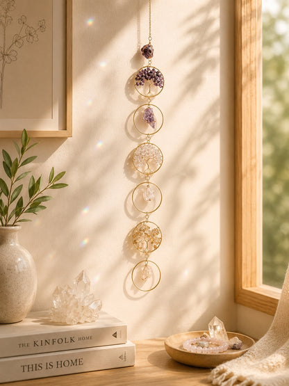 Colourful natural crystal tree of life hanging decoration displayed in a sunlit room.