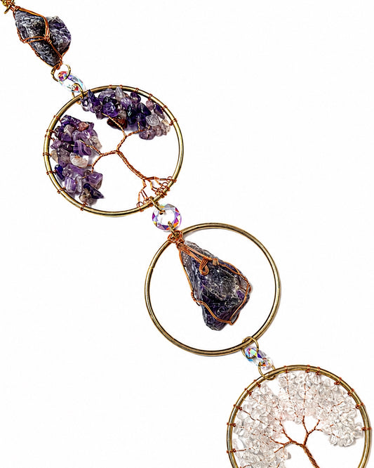 Close-up of purple and neutral natural crystal chip trees set in gold circular frames.