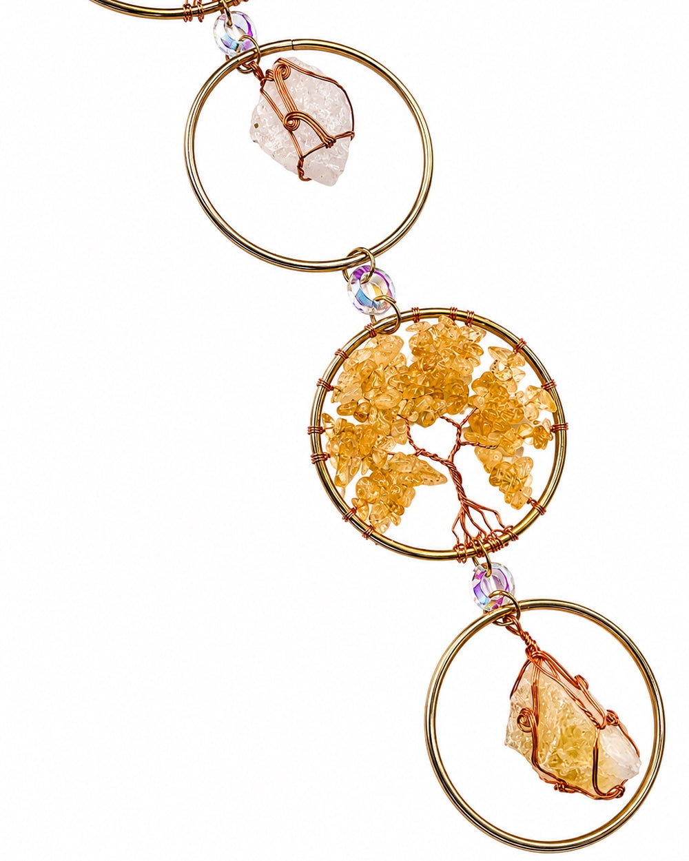 Close-up of warm-toned natural crystal chip trees set in gold circular frames.