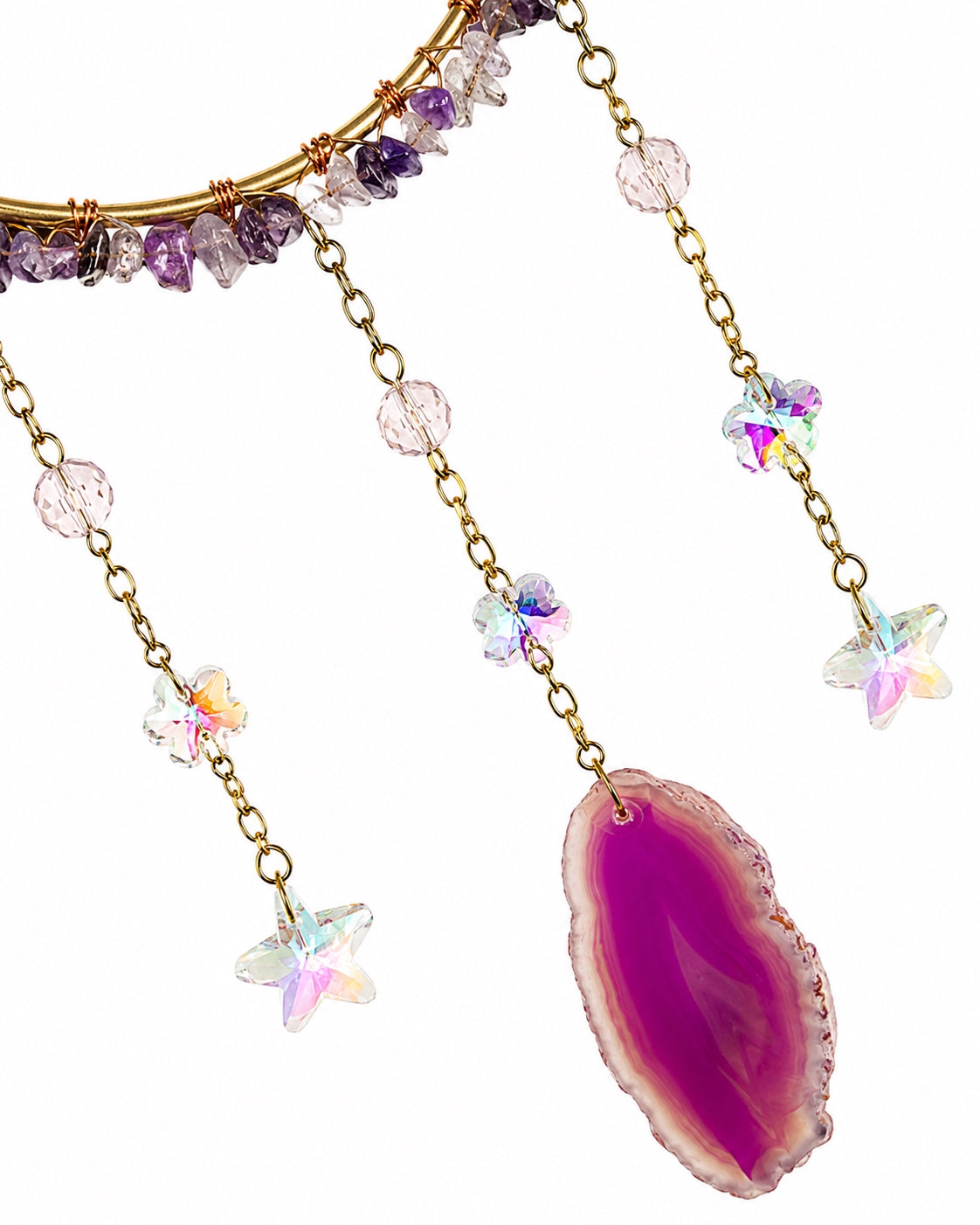 Close-up of iridescent crystal chains and a vibrant pink agate slice pendant on a handcrafted natural crystal suncatcher.